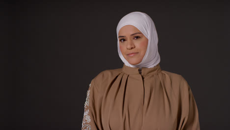 Studioporträt-Einer-Muslimischen-Frau-Mit-Hijab-Vor-Schlichtem,-Dunklem-Hintergrund